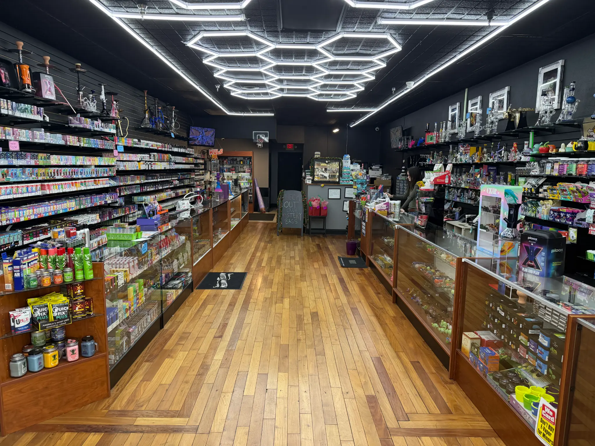 Puffology Smokeshop full store view with checkout counter, glass display cases, and premium vape selection in Brandon FL